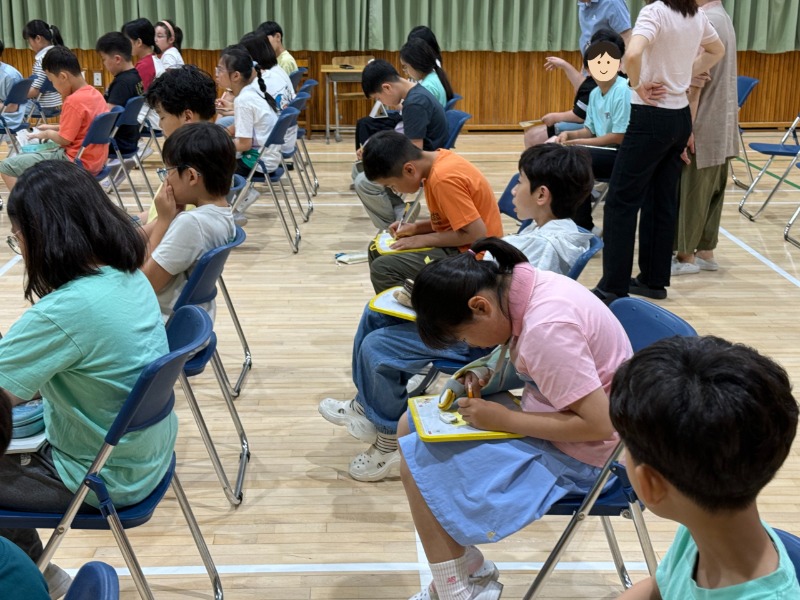 작은 손으로 열심히 편지를 쓰는 학생들