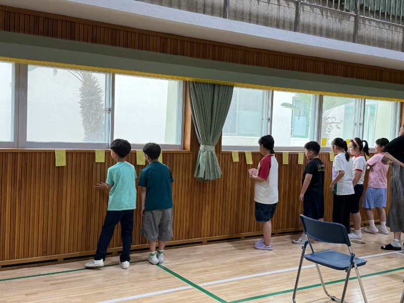 강당 벽면에 전시된 편지를 읽는 학생들