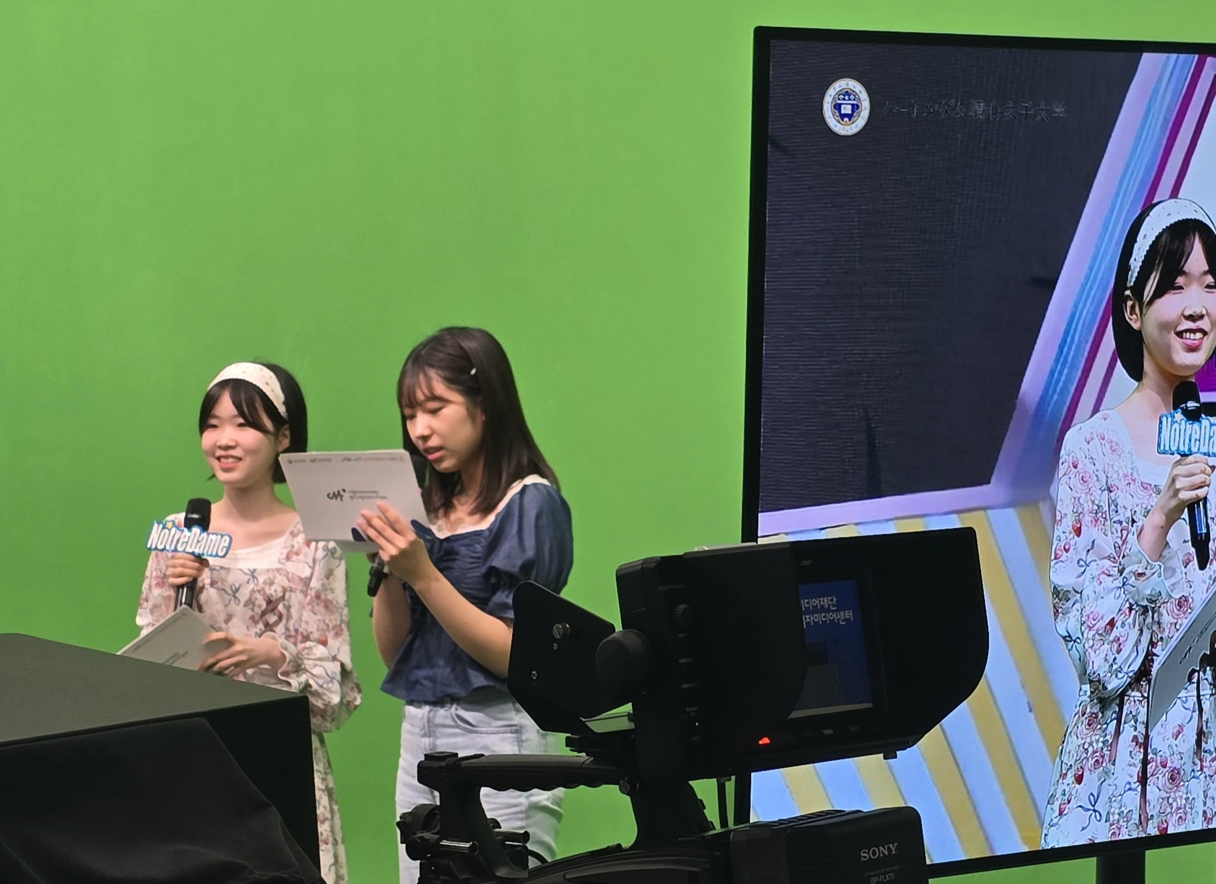 큐시트와 마이크를 들고 체험에 참여하고 있는 MC역할의 학생 2명
